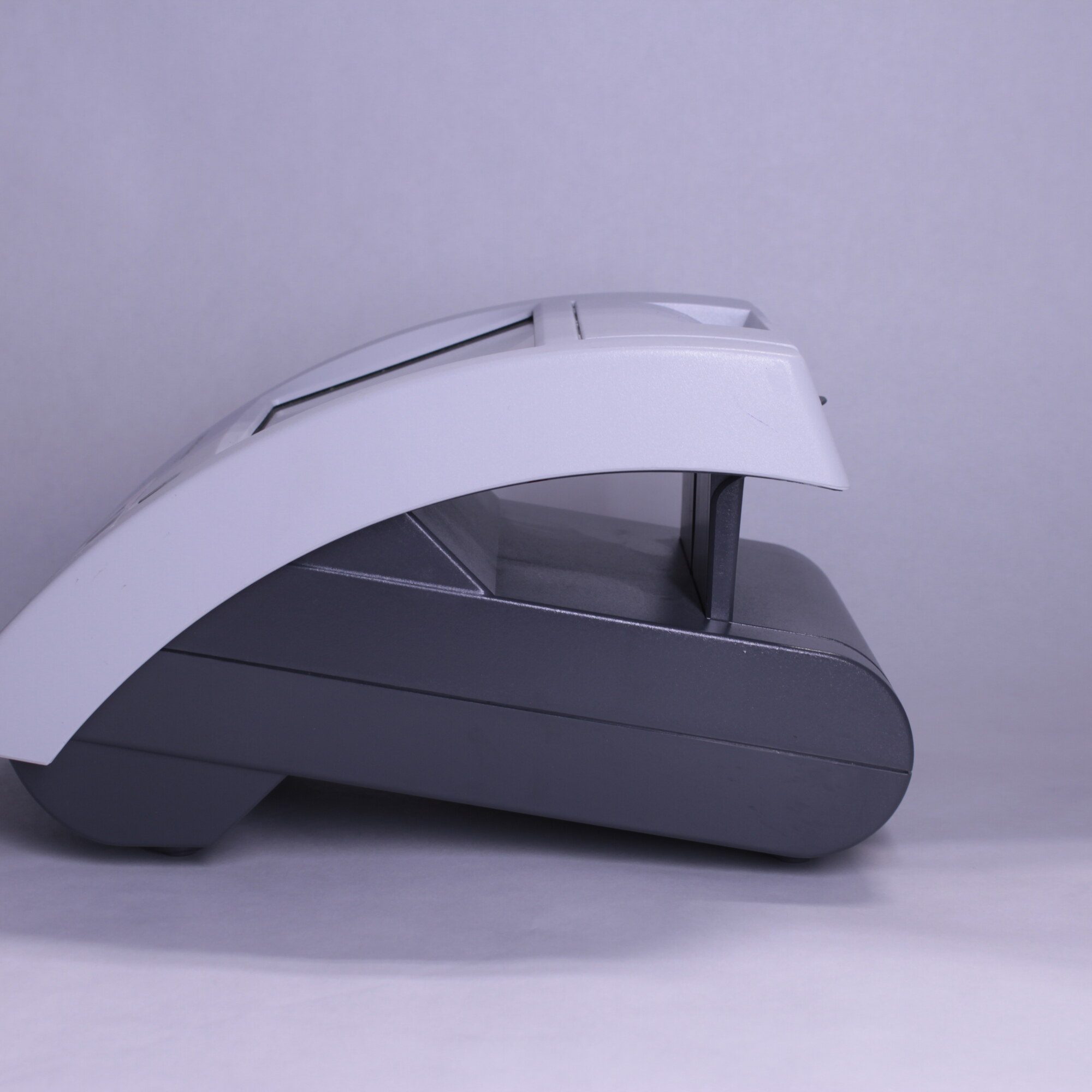 Left side profile of Siemens Clinitek Status+ urinalysis analyzer showing housing shape and minimal cosmetic wear