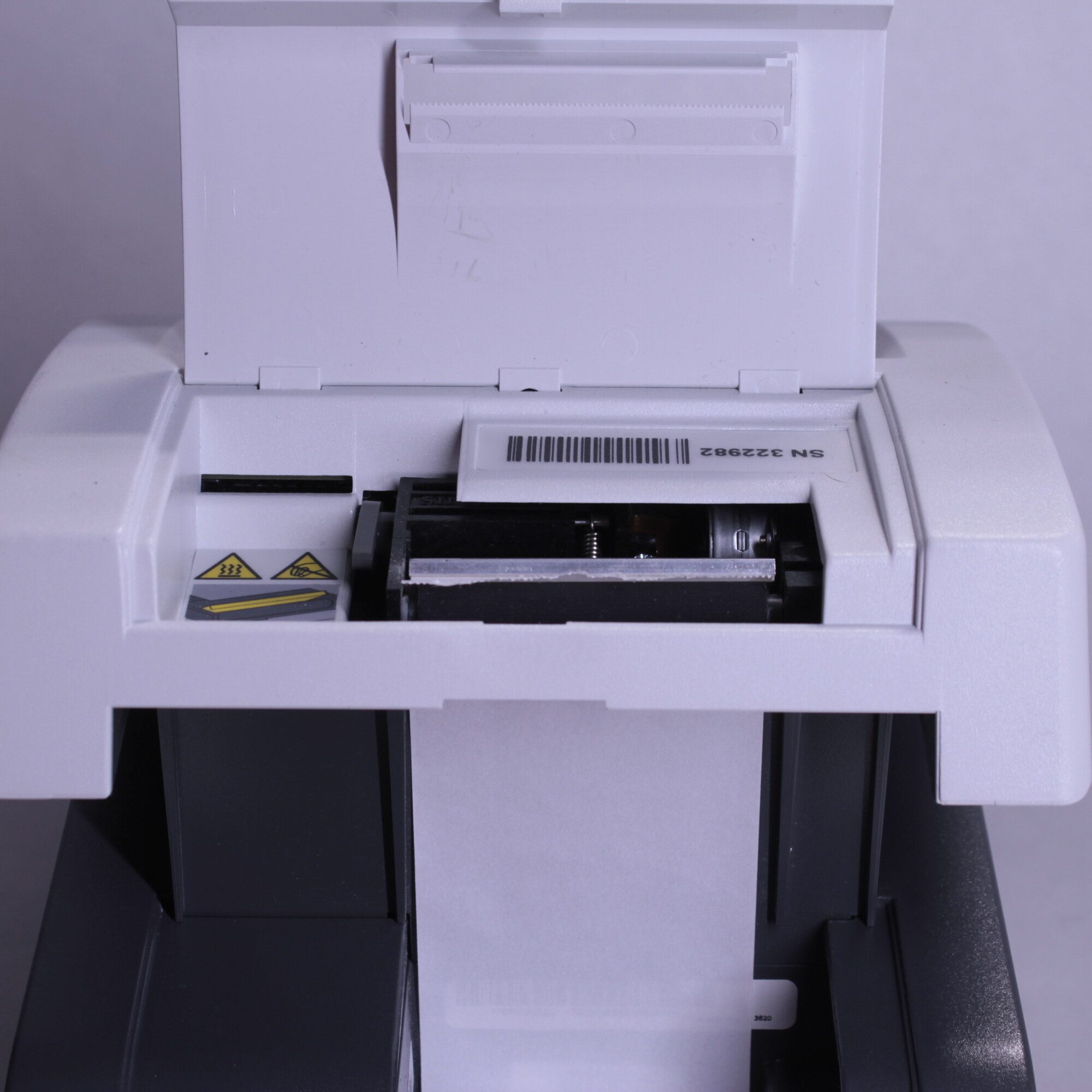 Close-up of Siemens Clinitek Status+ analyzer thermal printer mechanism and installed paper roll