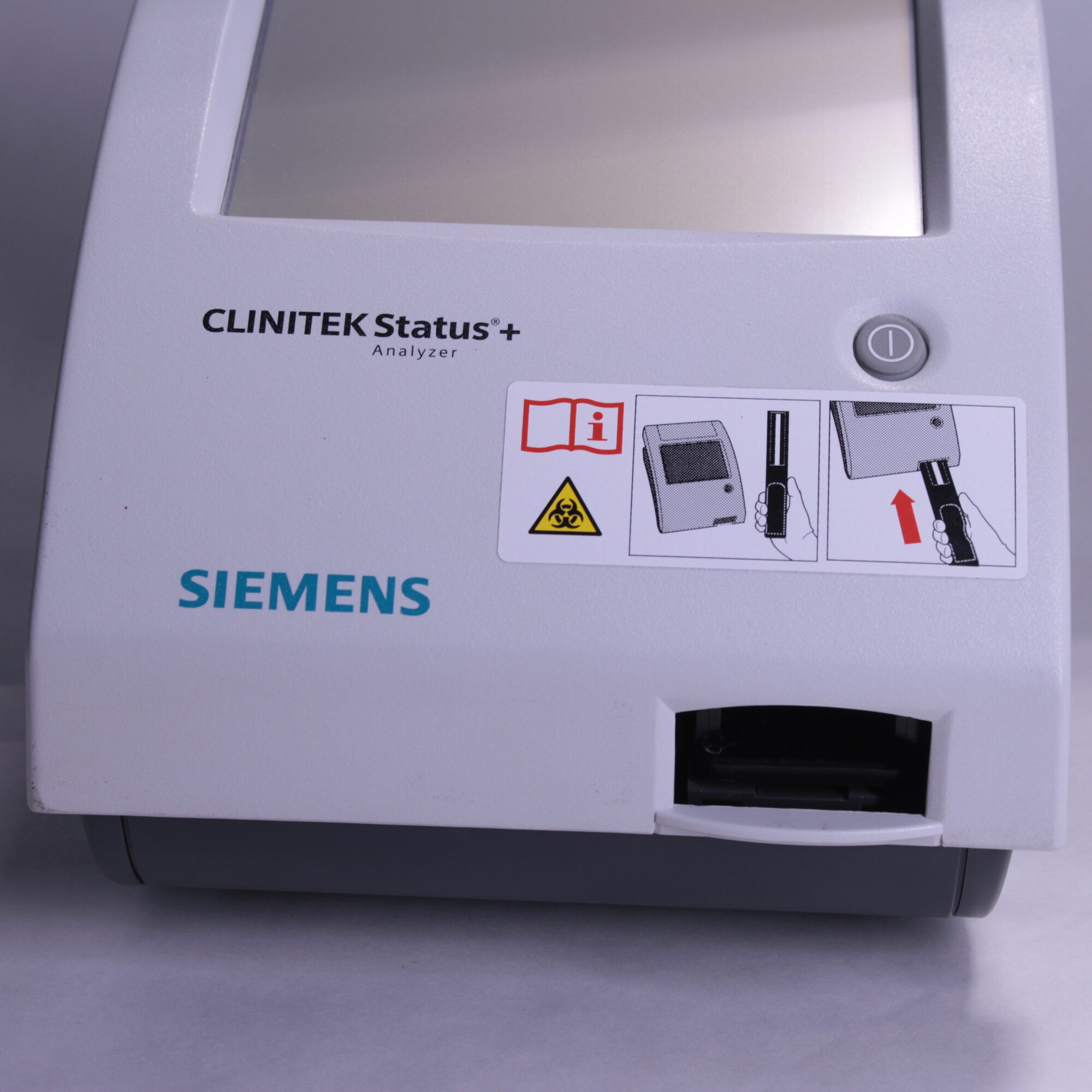 Close-up of Siemens Clinitek Status+ analyzer front panel with Siemens logo, power button and strip entry slot