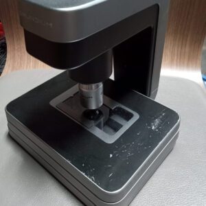 Grundium Ocus 40 microscope slide scanner front view with 40x objective and slide stage