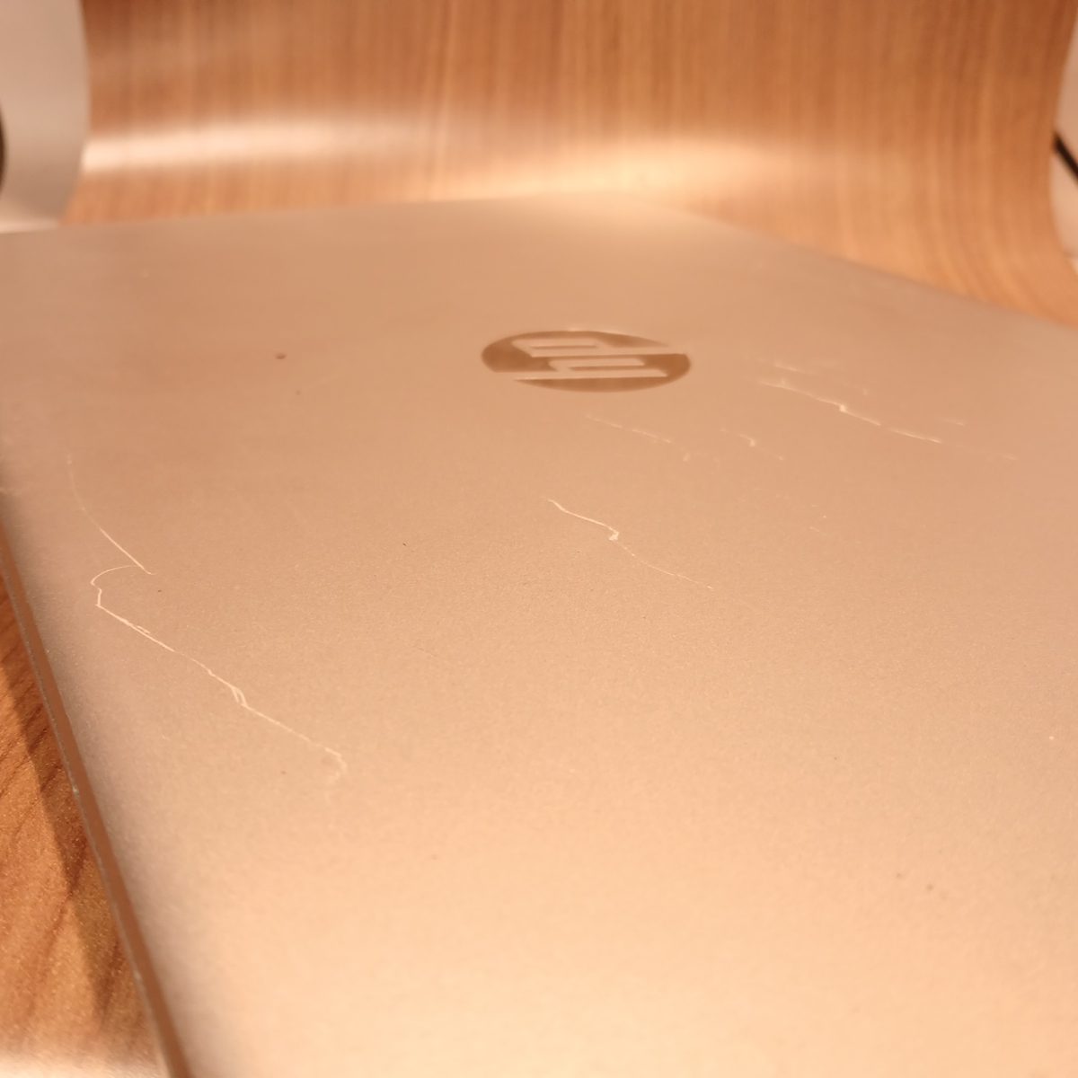 Angled top cover view of HP 15-dy2091wm showing scratches and exterior condition
