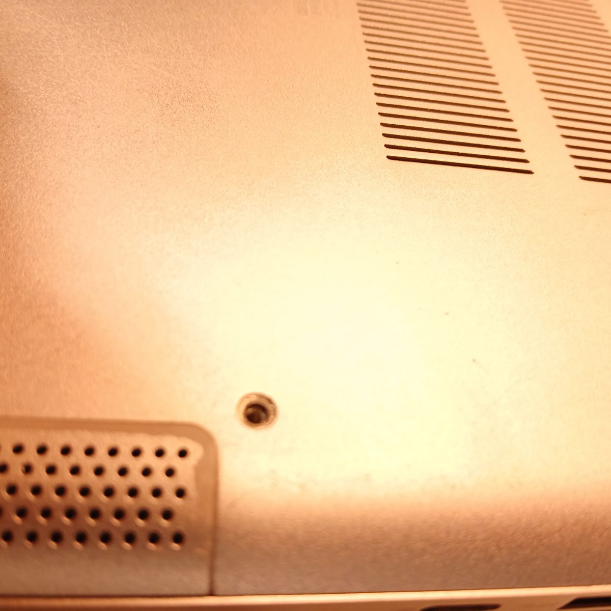 Close-up of bottom corner on Dell Inspiron 15 7501 showing speaker grille and screw mount