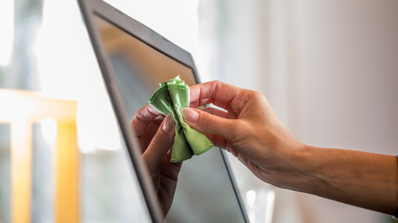 hand cleaning a computer screen